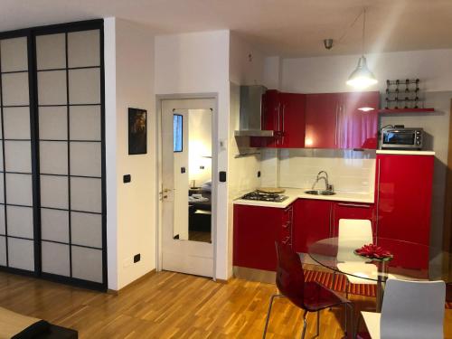 cocina con armarios rojos y mesa de cristal en gardasee sirmione, en Sirmione