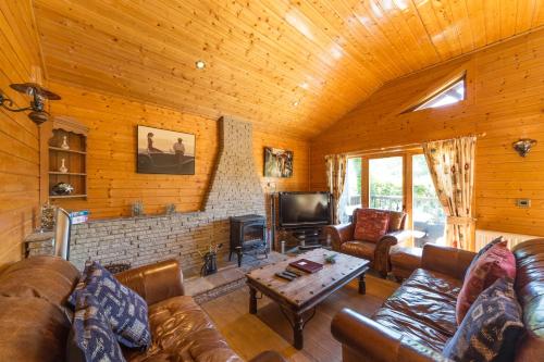 a living room with couches and a fireplace in a cabin at Oaks Log Cabins in Swanage