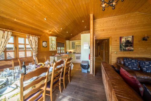 een eetkamer met een tafel en een bank bij Oaks Log Cabins in Swanage