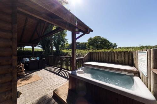 a hot tub on the deck of a house at Oaks Log Cabins in Swanage
