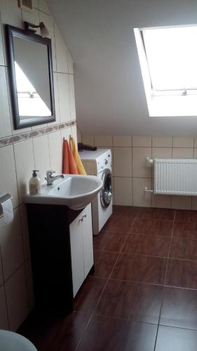 a bathroom with a sink and a washing machine at APARTAMENT NA DOBY - LUBIN in Lubin