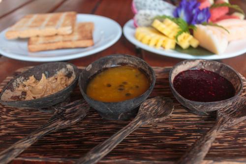 una mesa de madera con cucharas y platos de comida en The Moken Eco Village, en Ko Phra Thong