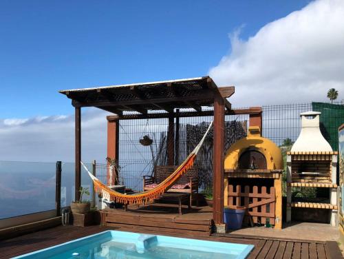 a hammock on a deck next to a swimming pool at Apartamento Drago de StarApsTenerife in Sauzal