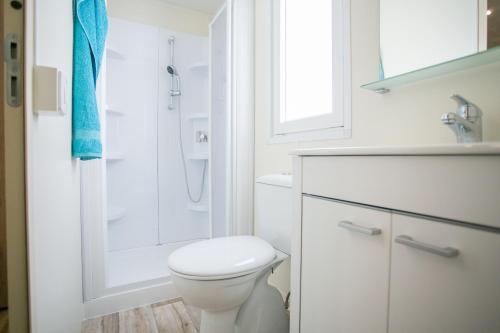 een witte badkamer met een toilet en een douche bij Mobile homes Premium MAGNOLIA Bijela Uvala in Poreč