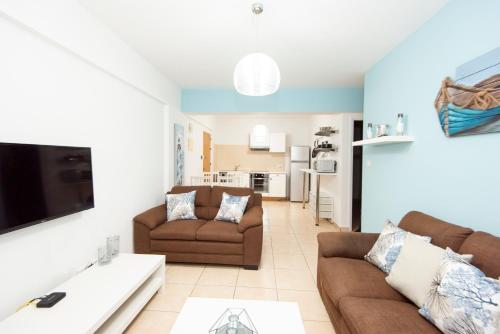 a living room with two couches and a tv at Olympia flat 201 in Larnaca