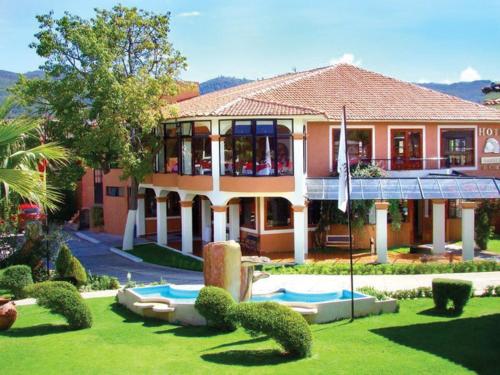 a large house with a garden in front of it at Hotel Arrecife de Coral in San Cristóbal de Las Casas