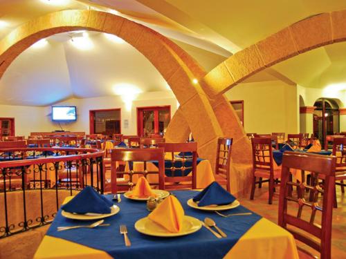 a dining room with tables and chairs with a blue table cloth at Hotel Arrecife de Coral in San Cristóbal de Las Casas