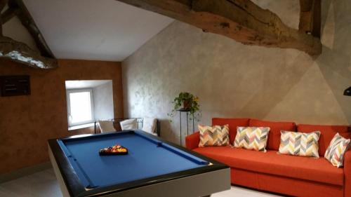 a pool table in a living room with a red couch at Domaine Christanna in Lisle-sur-Tarn