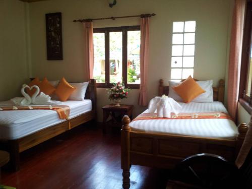 two beds in a room with two windows at Pranee Bungalow in Koh Tao