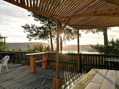 une terrasse en bois avec une pergola et une table dans l'établissement Vista Hermosa, à Constitución