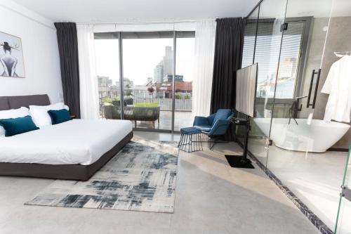 a bedroom with a bed and a bathroom with a tub at Emilia TLV in Tel Aviv
