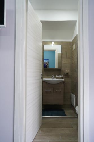 La salle de bains est pourvue d'un lavabo et d'un miroir. dans l'établissement Cristal Home, à Naples