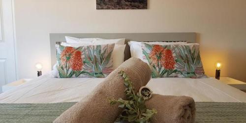 una camera da letto con un letto con due cuscini sopra di Mayfair Farm Cottages a Oudtshoorn
