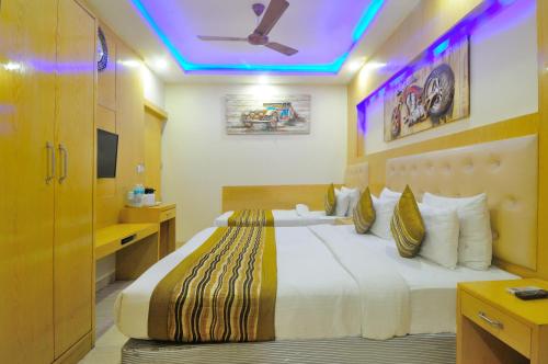 a bedroom with a large bed with a purple ceiling at Hotel Prince Palace Deluxe - New Delhi in New Delhi