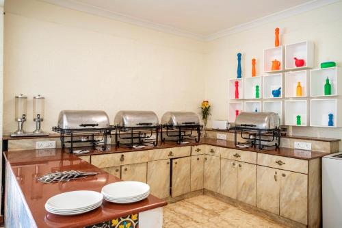 a kitchen with a counter with plates on it at Stone Wood Riverfront Resort, Siolim in Siolim
