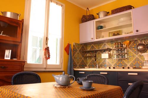 uma cozinha com uma mesa e uma cozinha com paredes amarelas em la terrazza em Vernazza