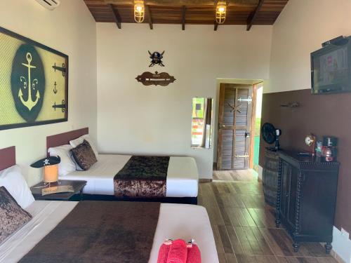 1 dormitorio con 2 camas y sofá en Mirante do Pirata Suítes Bed and Breakfast en Ubatuba