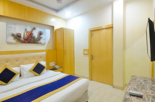 a hotel room with a bed and a television at Hotel Prince Palace Deluxe - New Delhi in New Delhi