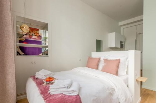 une chambre avec un lit blanc avec des serviettes dessus dans l'établissement Appartement Panthéon - Feuillantines, à Paris