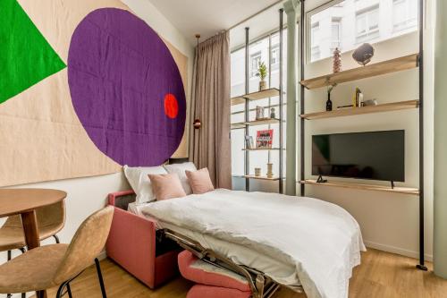 une chambre avec un lit, une table et une télévision dans l'établissement Appartement Panthéon - Feuillantines, à Paris