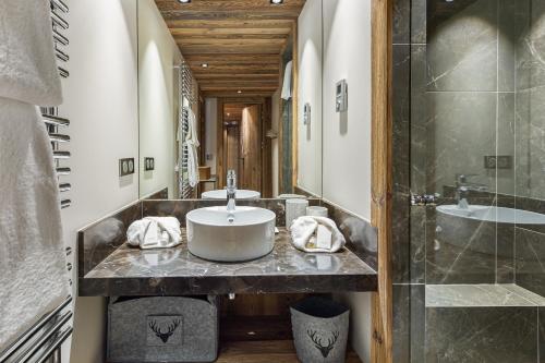 uma casa de banho com um lavatório e um chuveiro em Appartement Ourson - LES CHALETS COVAREL em Val dʼIsère