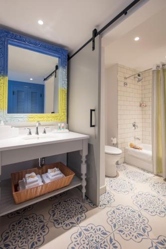a bathroom with a sink and a tub and a toilet at Universal's Loews Sapphire Falls Resort in Orlando