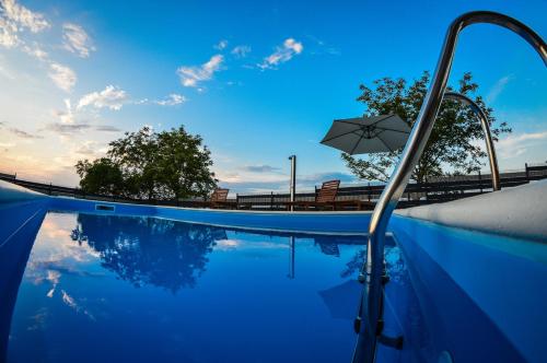- une piscine avec un parasol et le ciel dans l'établissement Holiday Home Gračec, à Gračec