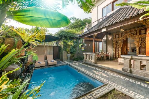 a swimming pool in the backyard of a house at Ashanti Villa Ubud in Ubud