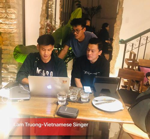 a group of men sitting at a table with a laptop at Leaf Signature Hotel - Lá Group in Ho Chi Minh City