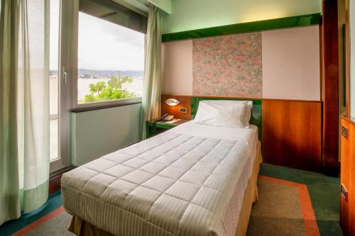 a bedroom with a large bed and a window at Hotel Royal Palace in Messina