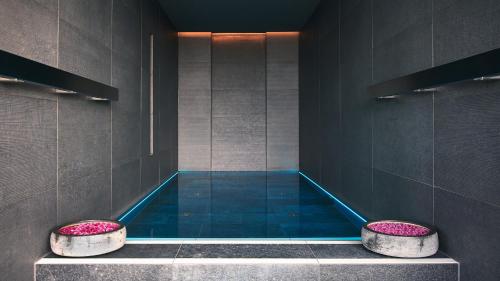 a bathroom with a swimming pool with two stools at The Mandala Berlin, a Member of Design Hotels in Berlin