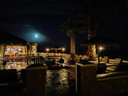 a restaurant with chairs and tables at night at Villa Manos Hotel in Karterados