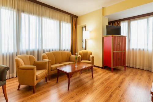 a living room with chairs and a table and a tv at Hotel Royal Palace in Messina