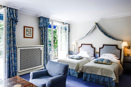 una camera con due letti e una sedia di Hotel Bayerischer Hof a Monaco
