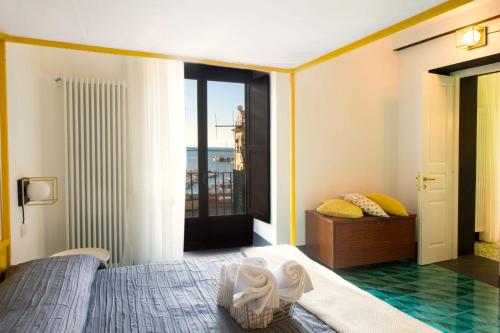 1 dormitorio con 1 cama y vistas a un balcón en Ninina Boutique Suites, en Salerno