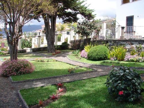 un giardino con alberi e fiori di fronte a un edificio di Purple Studio a Funchal