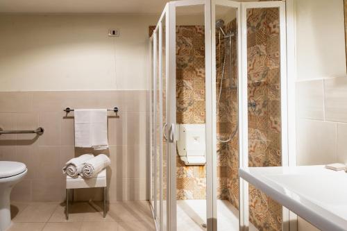 a bathroom with a toilet, sink and shower at Hotel Royal Palace in Messina