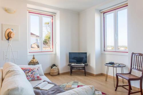a living room with a couch and a tv at Casa Alegre, Overlooking Sintra in Sintra