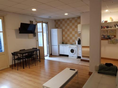 a living room with a table and a kitchen at Donostia Apartment Parking Included in San Sebastián