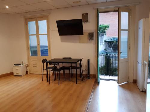 a room with a table and chairs and a flat screen tv at Donostia Apartment Parking Included in San Sebastián