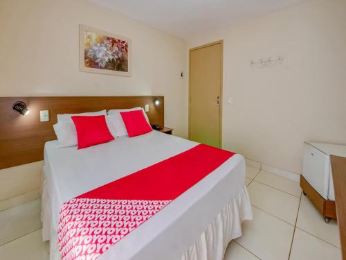 um quarto com uma cama com lençóis vermelhos e brancos em OYO Rio Colinas Hotel, Rio de Janeiro no Rio de Janeiro
