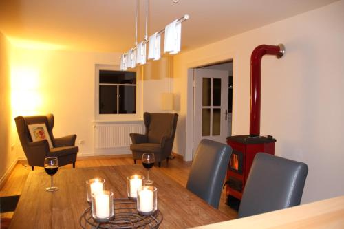 ein Esszimmer mit einem Tisch und Stühlen mit Weingläsern in der Unterkunft Die Kleine Villa in Zimmert