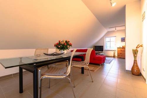 a dining room table with chairs and a red couch at Hof Garz in Poseritz