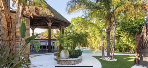 a garden with palm trees and a building at Villa Campito in El Puerto de Santa María