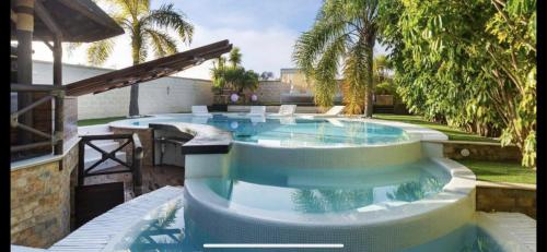 a large swimming pool in a yard with trees at Villa Campito in El Puerto de Santa María