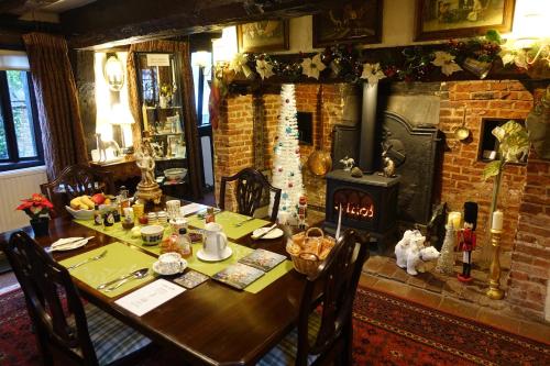 a dining room with a table and a fireplace at The Greyhound - Historic former Inn in Glemsford