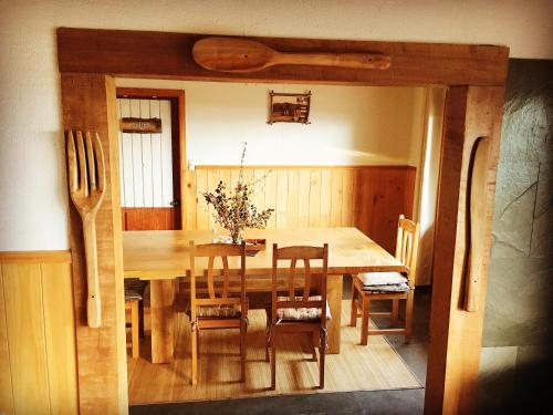 a dining room with a wooden table and chairs at Karibuni - Familiar Lodging & Private Spa in Villarrica