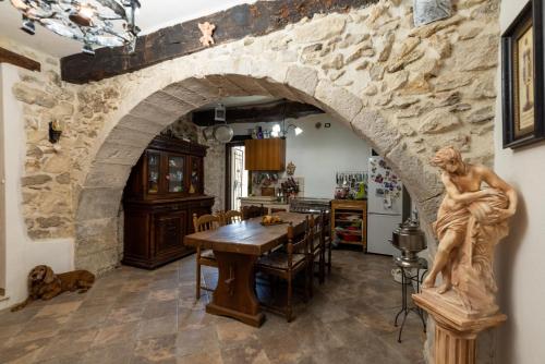 a kitchen with a stone wall and a table with a statue at La maison de Martine in Bolognano