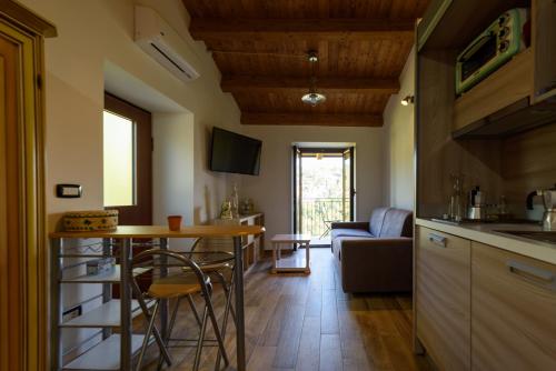 a kitchen and living room with a table and a couch at La maison de Martine in Bolognano