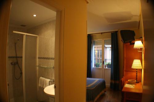 łazienka z łóżkiem, umywalką i prysznicem w obiekcie Pensión Bilbao w mieście Bilbao